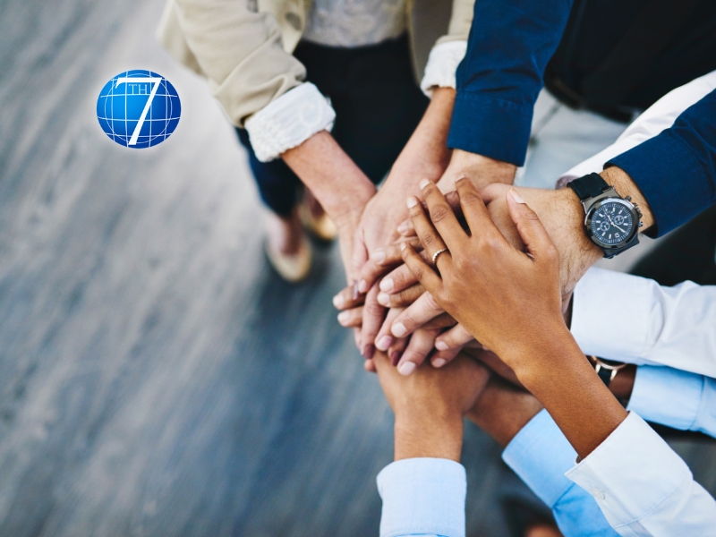 a group of diverse professionals collaborating in a modern office setting, highlighting unity and teamwork. Providing a warm, motivational tone to emphasize the theme of leveraging individual strengths within a team.