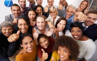 A diverse group of professionals, representing different genders, ages, and ethnic backgrounds, smiling and giving thumbs-up, symbolizing gender diversity in leadership and equal opportunities in the workplace.