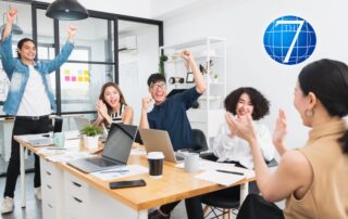 A cheerful team celebrating and collaborating in a modern office, demonstrating playfulness in leadership through an engaging and fun work environment.